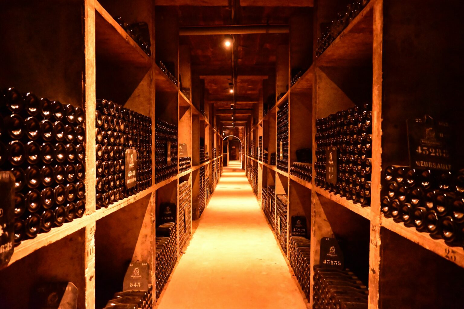 The Provenance Question: Why Wine Auctions Care More About Storage Than Vintage An underground bottle-aging cellar with rows of Meursault bottles on racks, illustrating the chain-of-custody storage that documented wine provenance requires.
