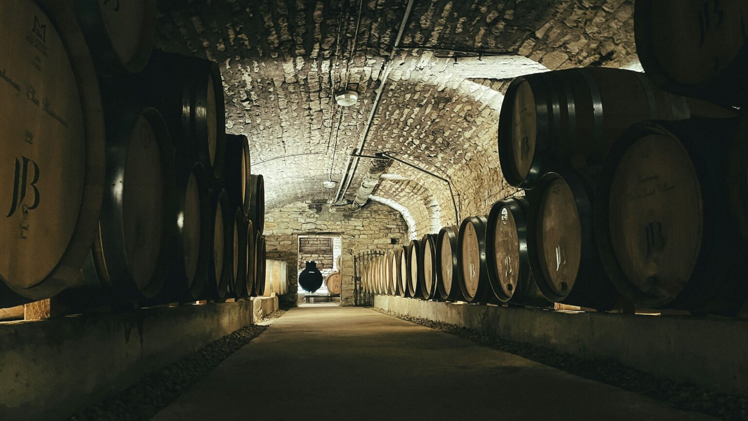 Bâtonnage: The Stick, The Lees, And Why Your Chardonnay Tastes Creamy Oak barrels in a wine cellar where bâtonnage, the stirring of lees, shapes the texture of barrel-fermented Chardonnay.